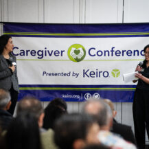 Roxy Kirakosyan and Keiro staff on stage with Caregiver Conference banner in background