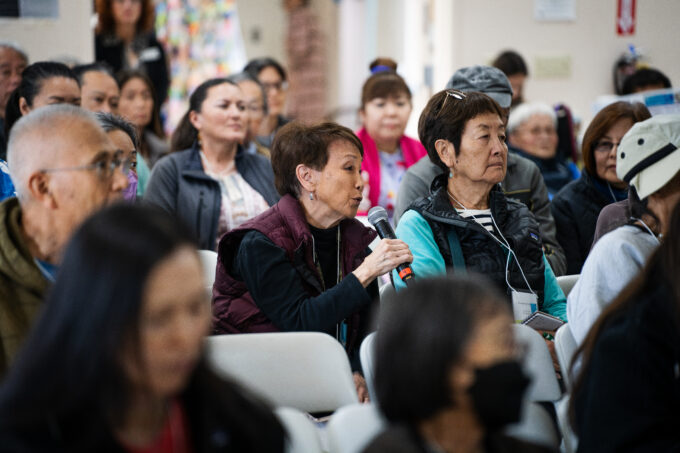 conference attendee speaking into microphone in crowd