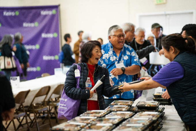 conference attendee smiling while receiving bento boxes