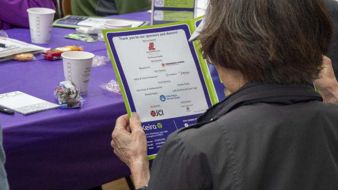 woman holding a program booklet with list of sponsors