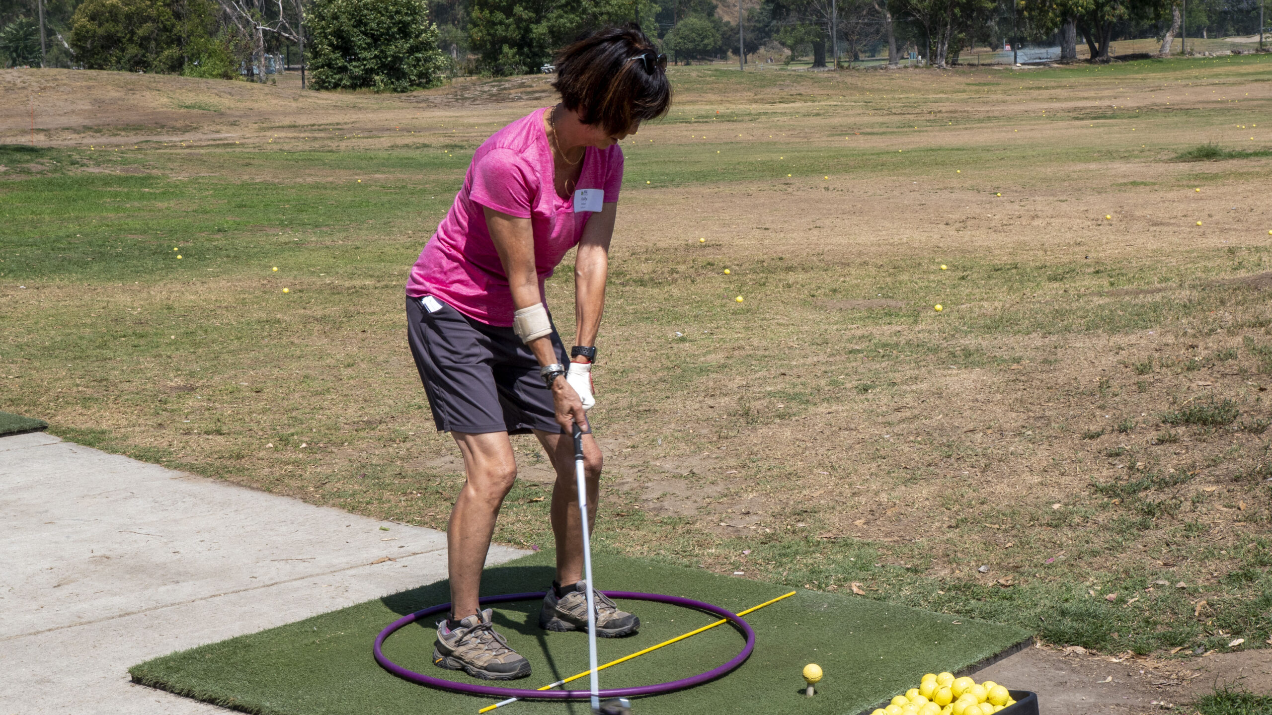 a woman in pink about to swing a golf club