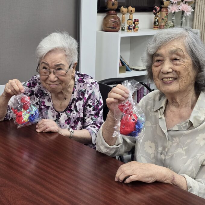 two women holding up gold fish craft