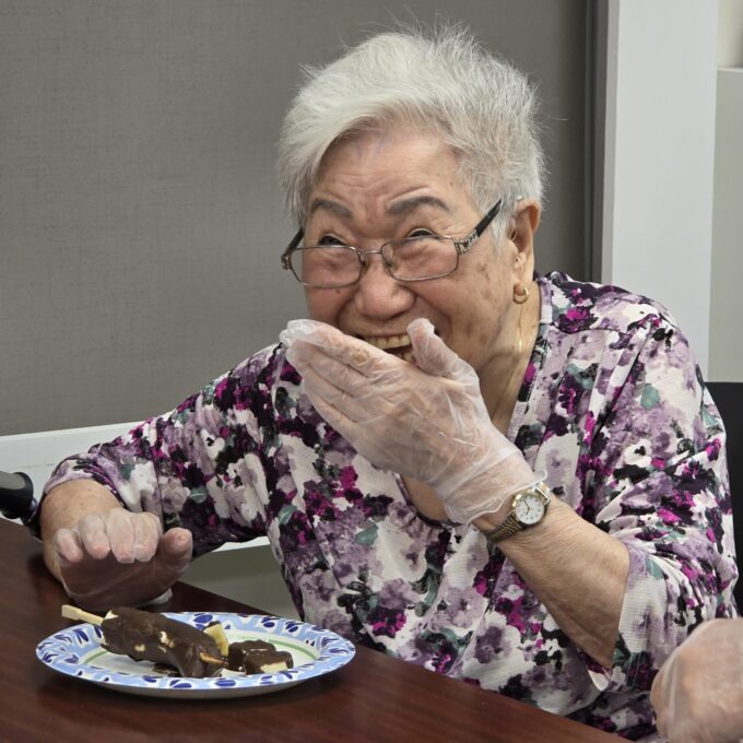 woman laughing while making a chocolate covered banana