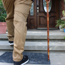 person's legs walking up stairs while holding a cane