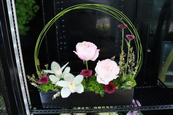 pink and white floral arrangement with arched greenery
