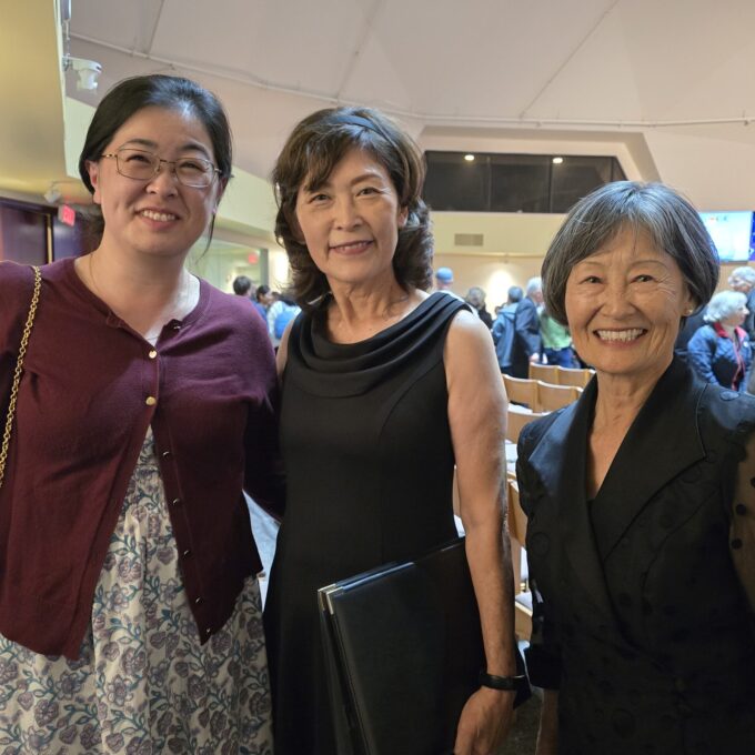 three women smiling at concert