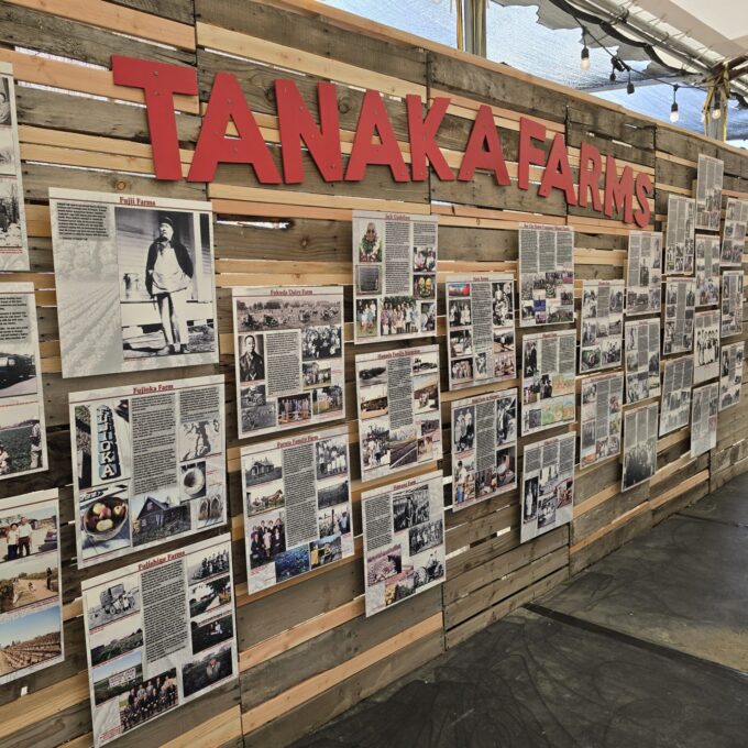 wall with pictures and red words that read "Tanaka Farms"