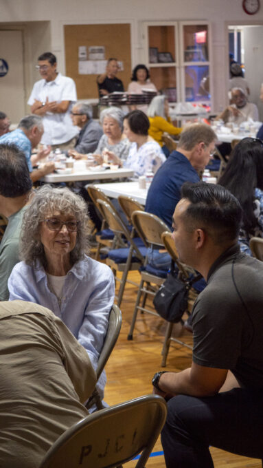 a woman in blue button up talking with a man in a black polo