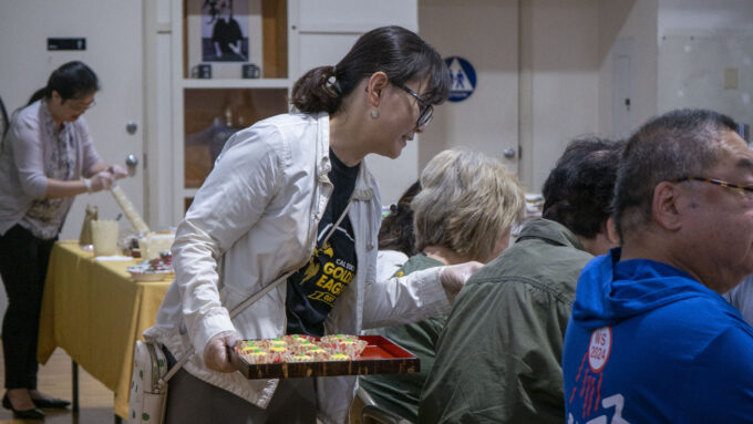 a woman serving wagashi on a platter