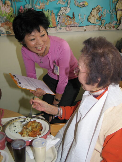 Beverly Ito smiling with a resident, 2006