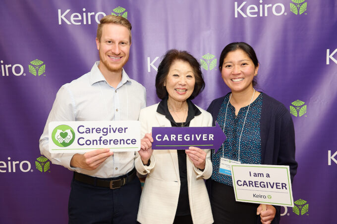 Beverly Ito holding caregiver signs with daughter and son in law