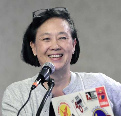 woman smiling speaking into a microphone