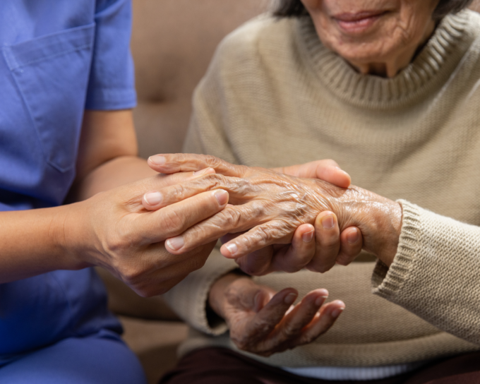 younger woman holding onto older adult hands