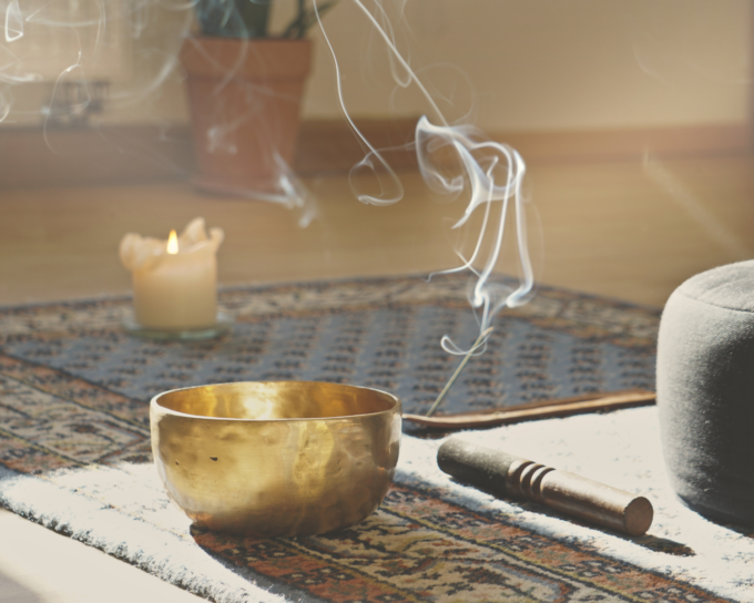 candle on rug with a sound bowl
