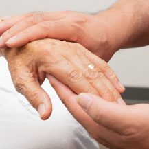 caregiver hands holding older adult's hands