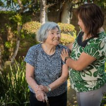 caregiver and older adult smiling at each other