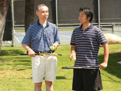Two adult men holding tennis rackets
