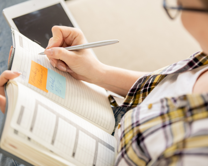 person writing in notebook