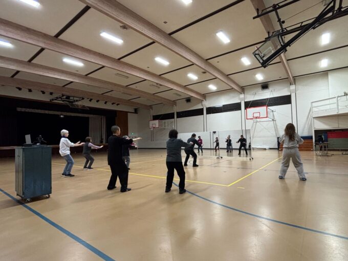 large gym of people doing tai chi