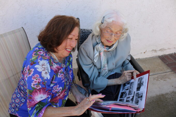 two women looking at old photos