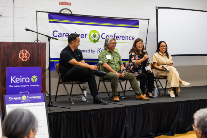 a group panel talking to a crowd