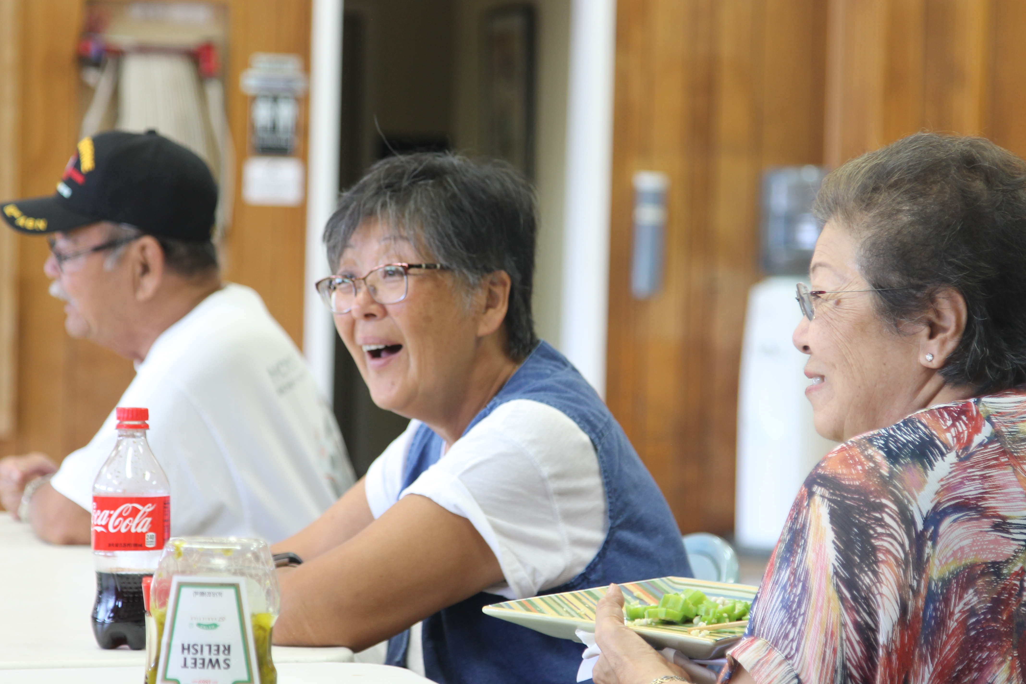 Three older adults sitting together and eating