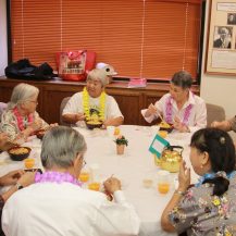 Adults sitting at a round table eating and talking