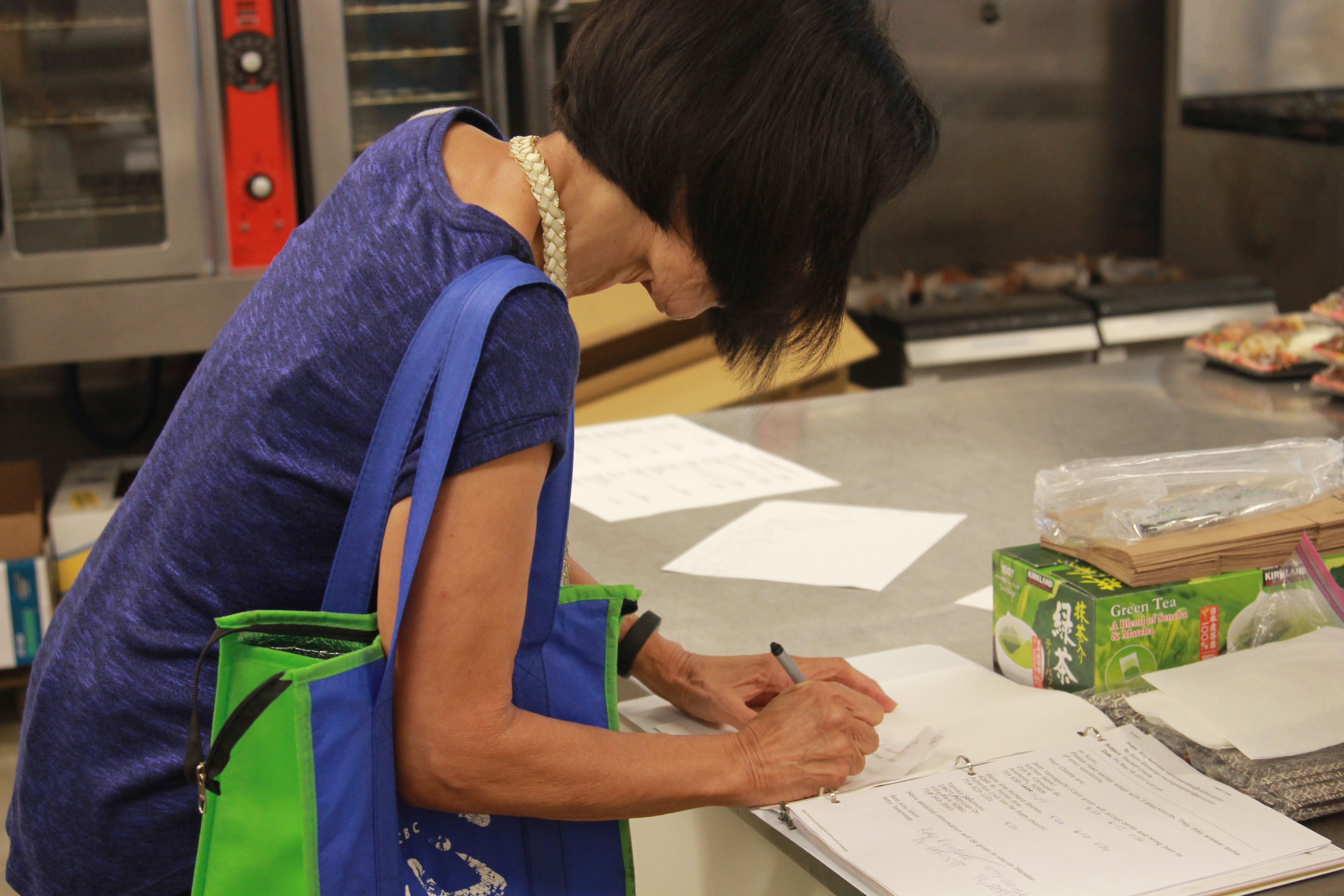 A volunteer filling out a form in a three-ring binder