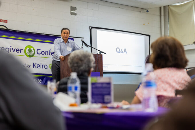 a man in a blue button down talking on a podium
