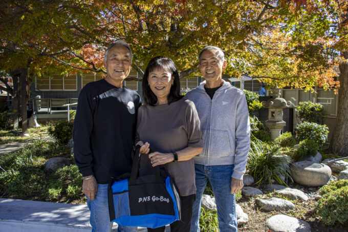 a man in black sweater, woman in brown long sleeve, and man in gray jacket
