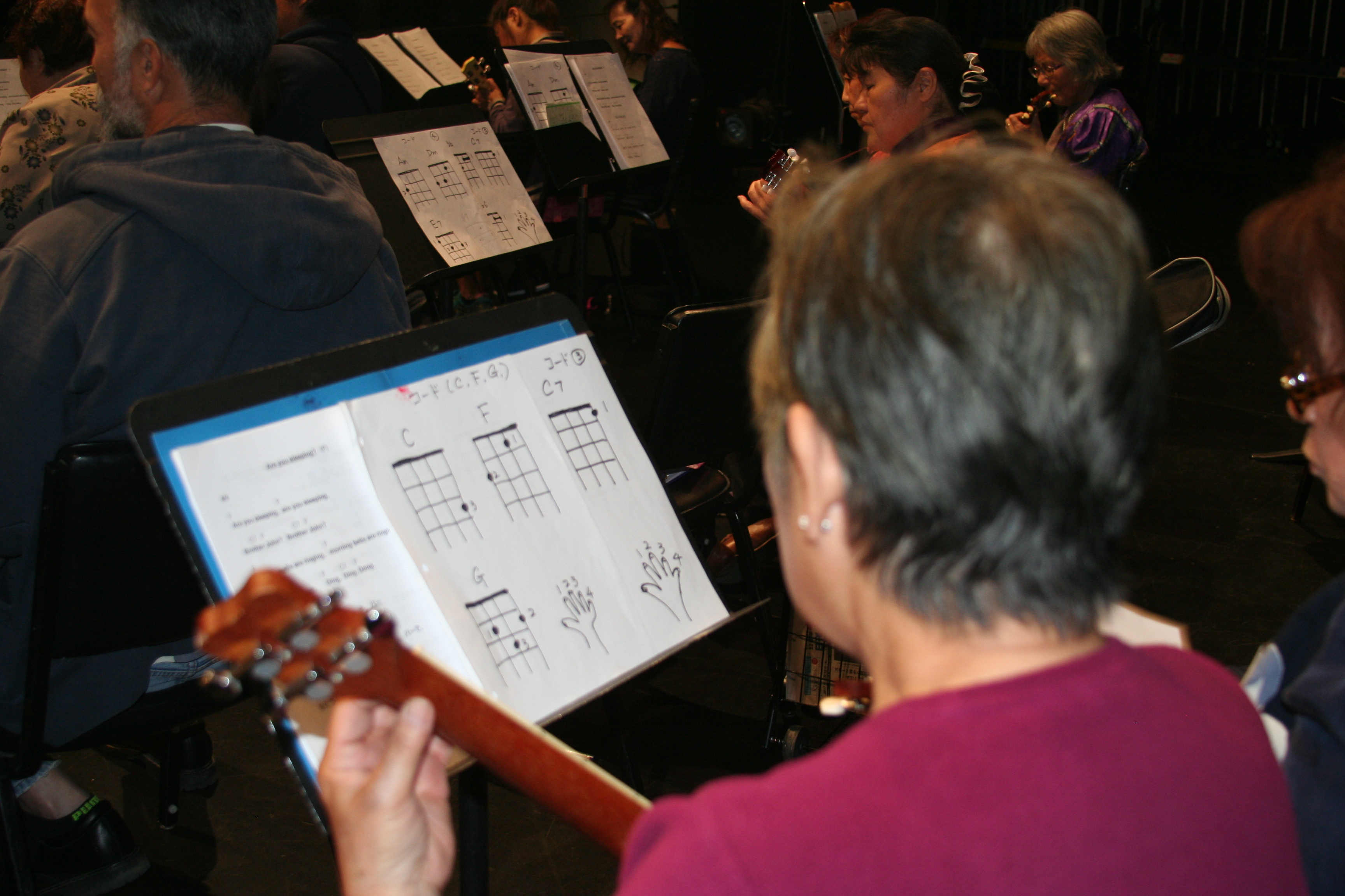 Older adult looks at sheet music for the ukulele