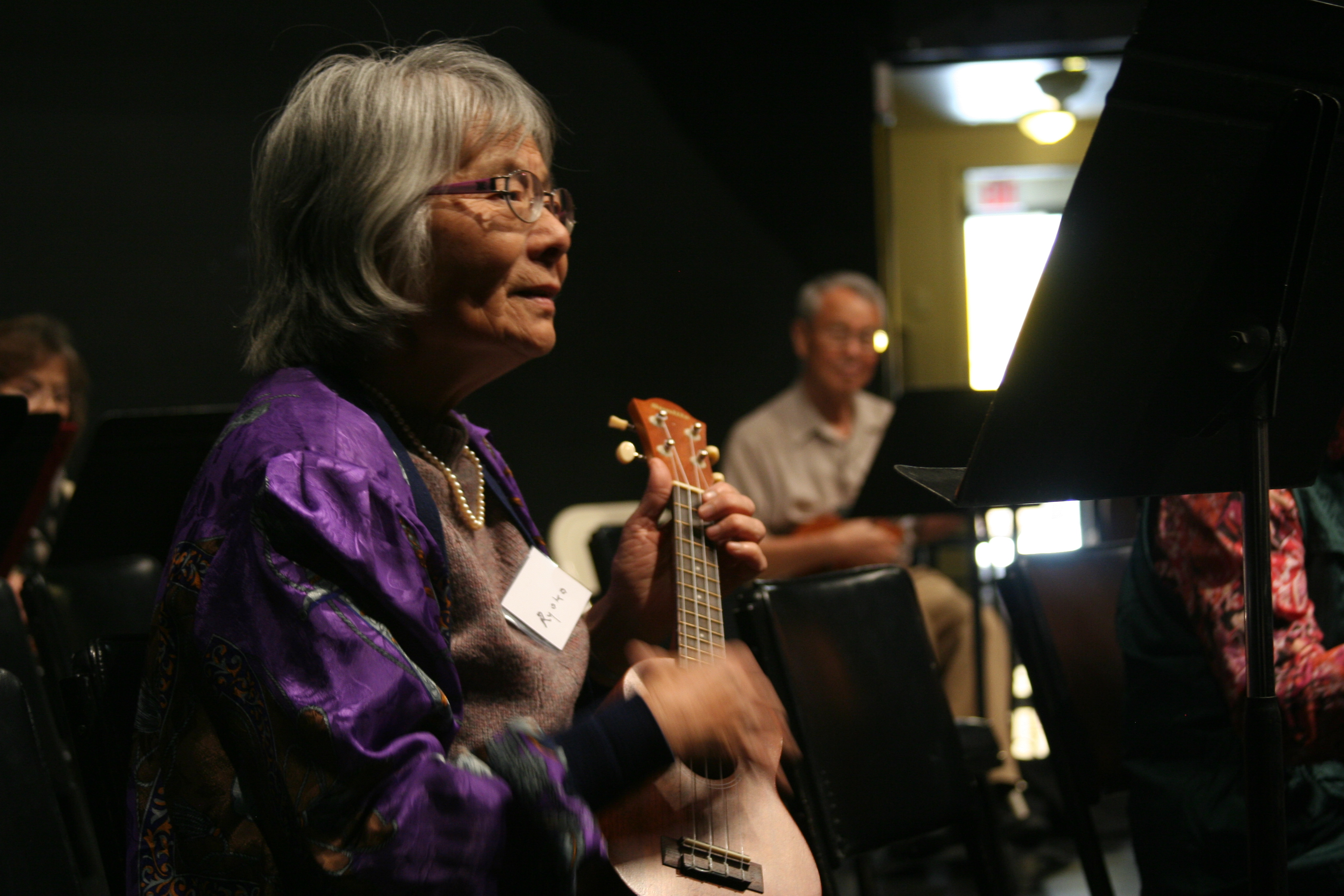 Older adult woman playing the ukulele