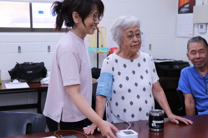 person taking an older adult's blood pressure