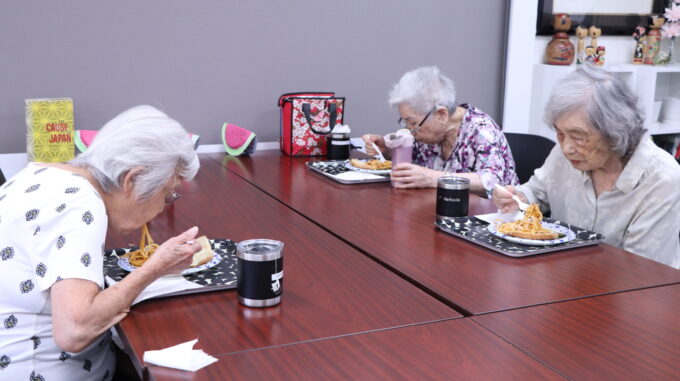 three people eating lunch at table