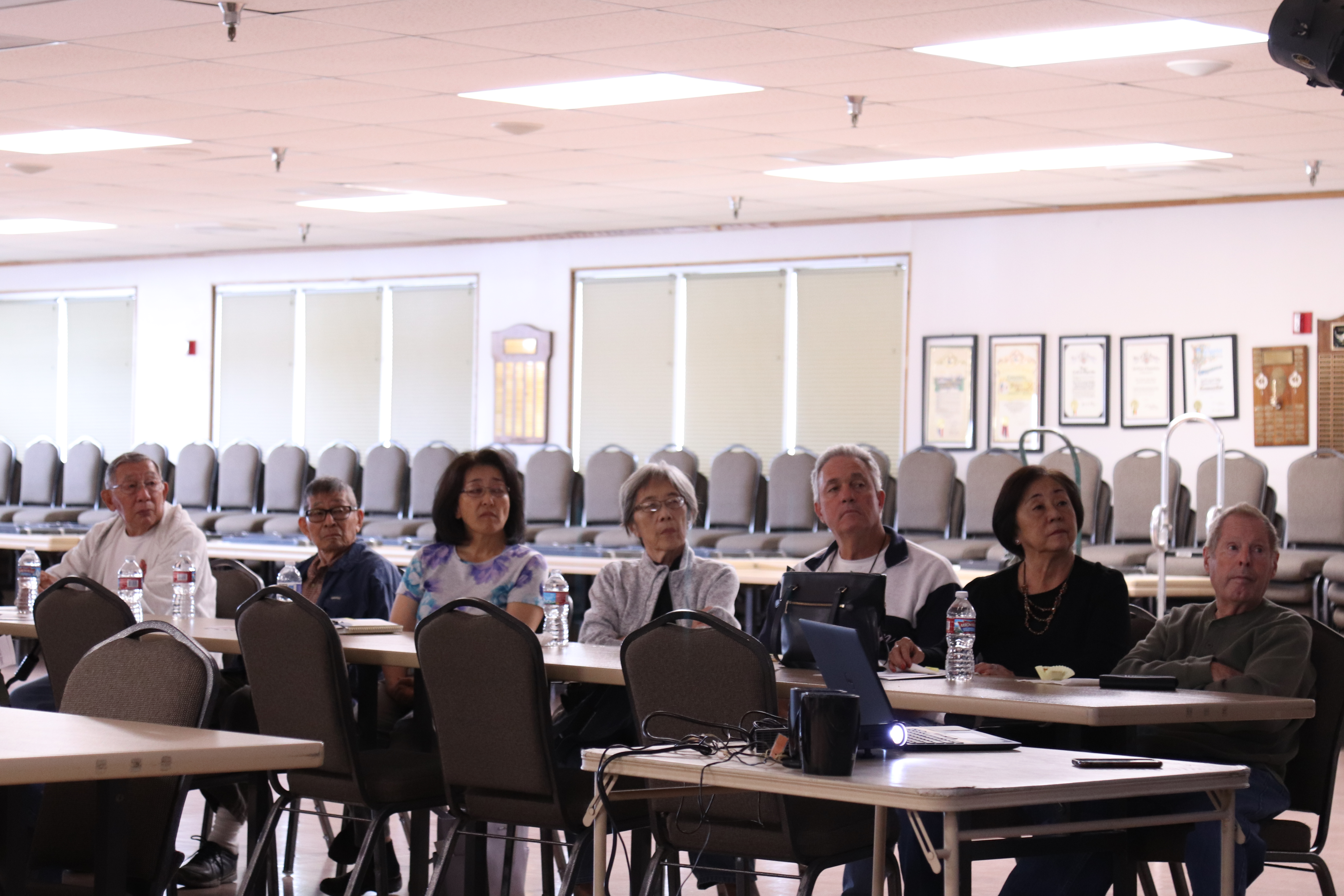 7 Adults at a table watching a presentation