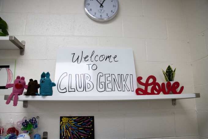 sign on shelf that reads "Welcome to ClubGenki"