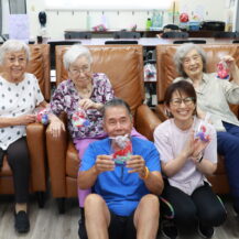 group of five people holding up gold fish craft