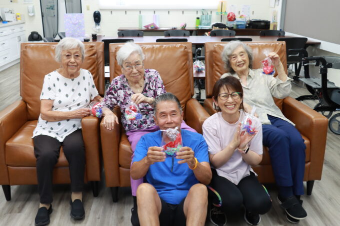 group of five people holding up gold fish craft
