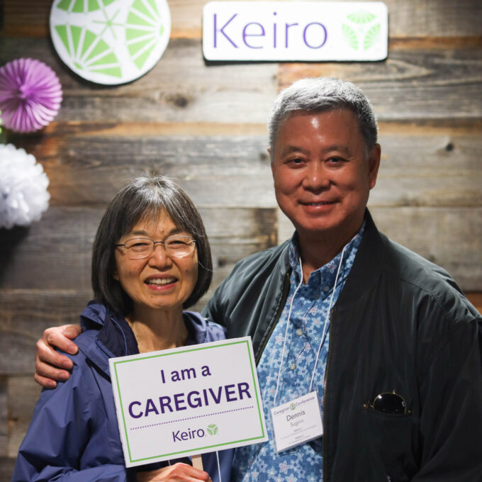 man and woman holding sign that says "I am a caregiver"