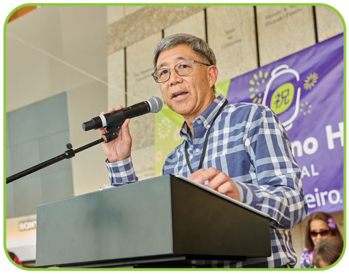 man speaking into microphone on a stage