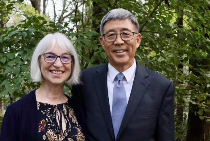man with blue tie and woman with dark pattern shirt outside