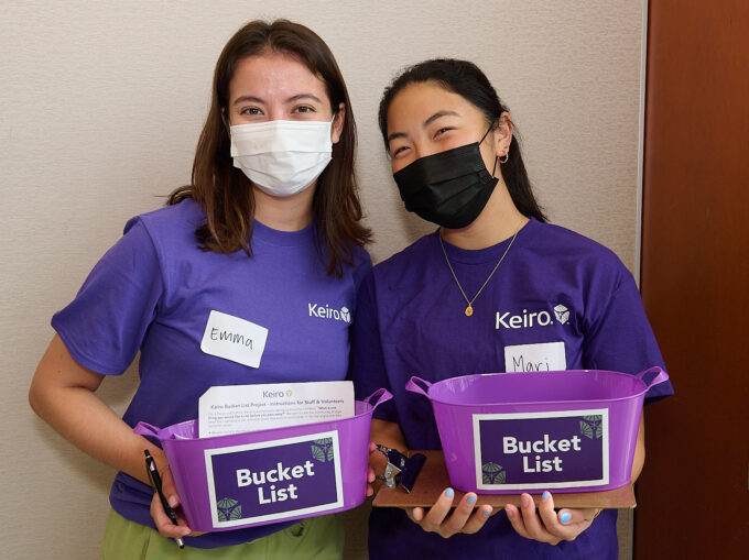 two girls holding buckets that say "bucket list"