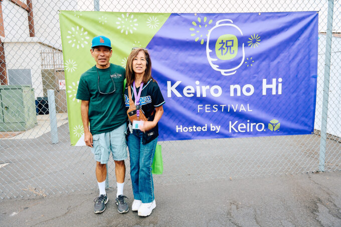 man and woman posing in front of Keiro no Hi Festival sign