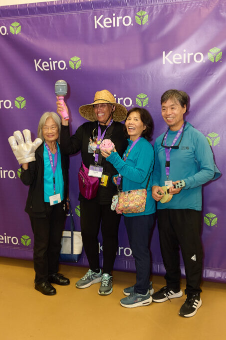 four people posing with photo booth props