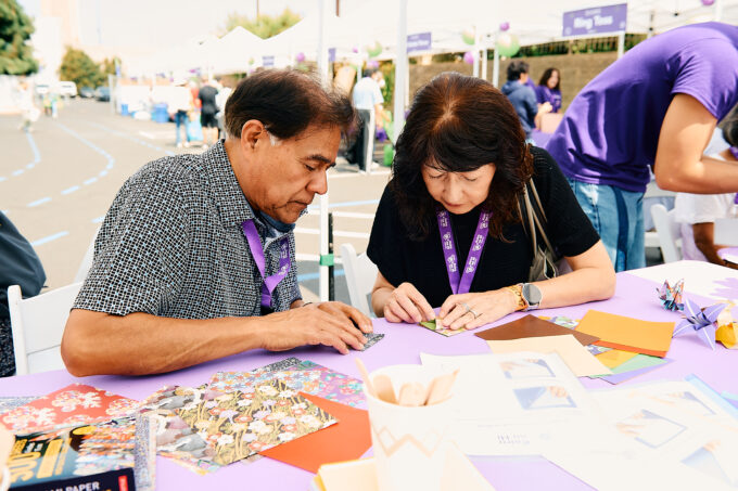 man and woman folding origami at table