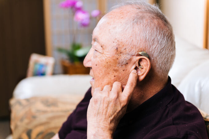 older adult with hearing aid