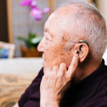 older adult with hearing aid