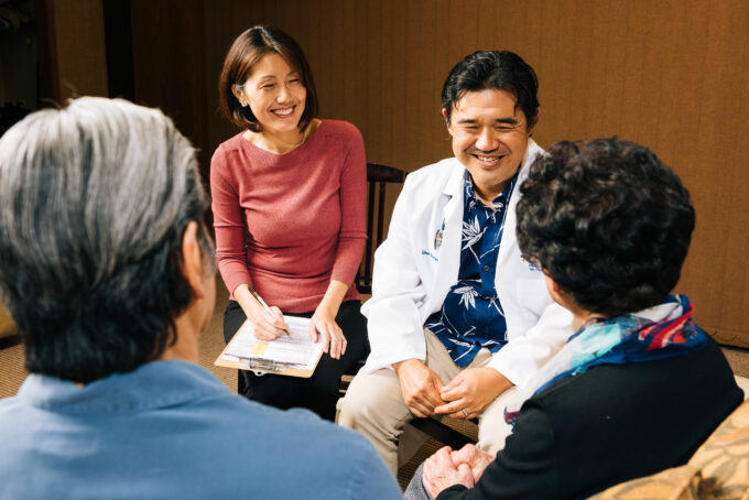 doctor and social worker talking to two older adults