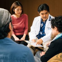 Iyashi Care doctor and social worker talking to a patient and their family member