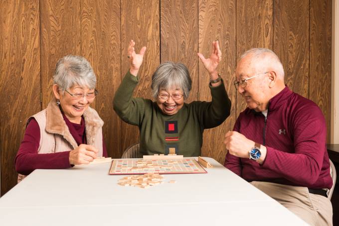 three older adults playing scrabble